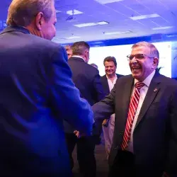 Dos hombres vestidos de traje dándose la mano.