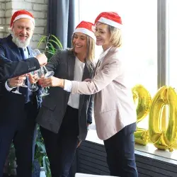 La gente de negocios está celebrando vacaciones en la oficina moderna bebiendo champán y divirtiéndose en el coworking. 