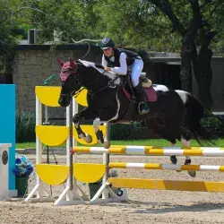 Renata Pepi montando su caballo en competencia de equitación.