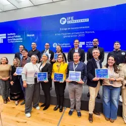 Grupo de docentes y directivos del Tecnológico de Monterrey posan con sus reconocimientos NOVUS durante la ceremonia de entrega a los mejores proyectos de innovación educativa generación 2023, en el marco de IFE Conference, frente a una pantalla institucional.
