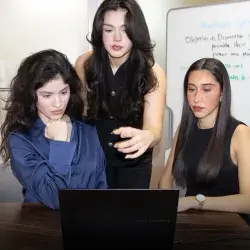 Tres chicas fronte a una computadora.