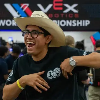 Alumno con sombrero sonriendo. 