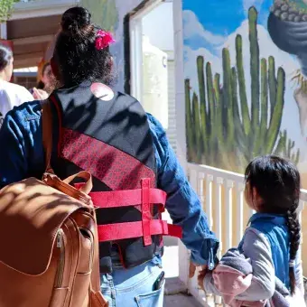 El evento estuvo abierto a la comunidad del Centro Hábitat Los Olivos en Hermosillo. Foto: Helena Armenta Vista de espaldas de una mujer caminando de la mano de una niña.