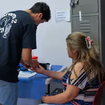 Foto: Helena Armenta Voluntario tomando la presión arterial de una mujer.