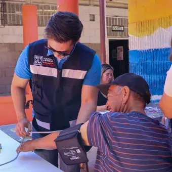 El evento contó con el apoyo de personal de la Secretaría de la Salud de Sonora. Foto: Helena Armenta Personal de Secretaría de la Salud le toma la presión a un hombre.