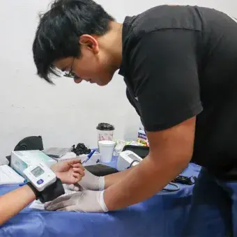 Foto: Emilio Morales  Joven voluntario tomando la presión arterial de una niña.