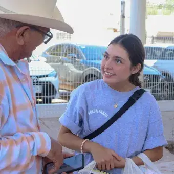 Foto: Emilio Morales Mujer joven platicando con hombre mayor.