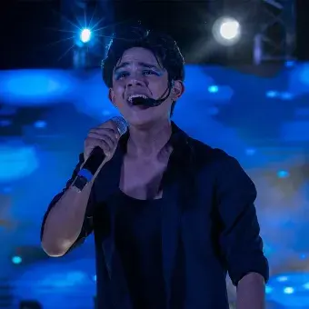 Alumnos cantando con micrófono en mano. 