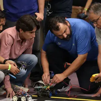 Estudiantes y profesores analizando un vehículo.