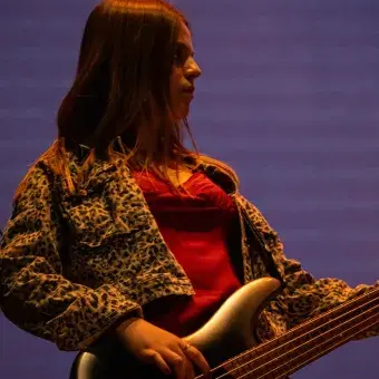 Foto: Blas Murillo Mujer bajista en escenario.