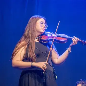 Alumna tocando el violín en musical Legalmente Rubia.