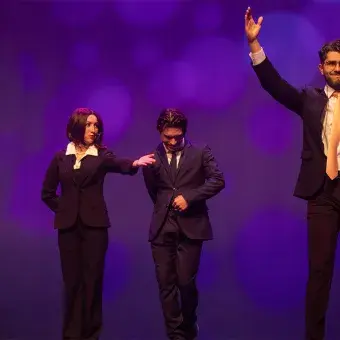 Estudiantes con brazos arriba en musical Legalmente Rubia.