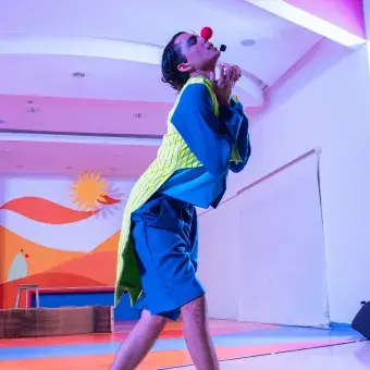 Actor con vestuario y nariz de payaso.